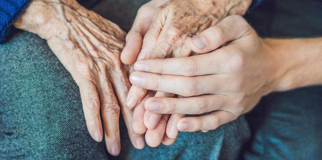 Hands of an old woman and a young man close up.